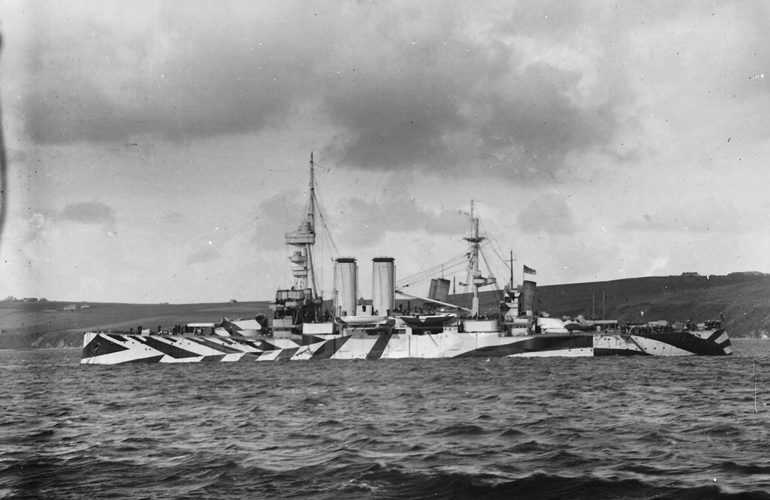 King Edward VII-class pre-dreadnought battleship HMS Commonwealth in dazzle camouflage, at anchor at Scapa Flow, 1918.