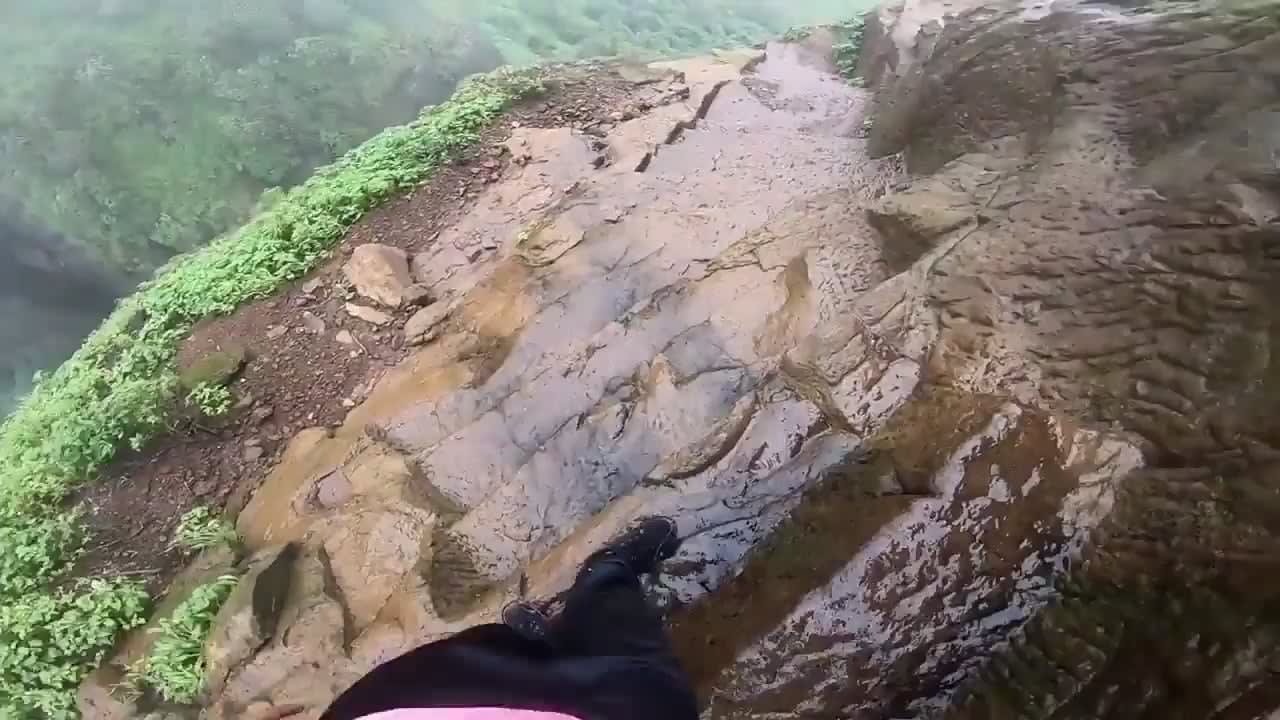 Trek towards Kalavnatin Fort in Maharashtra, India. (686m high summit) without any form of security measure taken. The man is a legend doing parts of this slippery trek with just one hand!