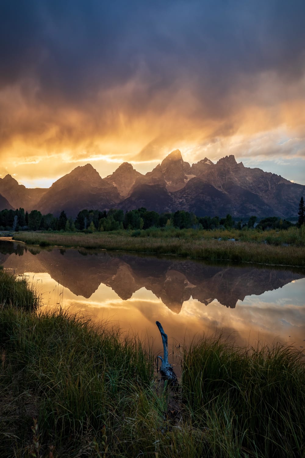 Thunderstorms were all around me echoing in the distance, but it remained calm where I was standing creating an ominous sky and reflection - Grand Teton National Park IG: @travlonghorns