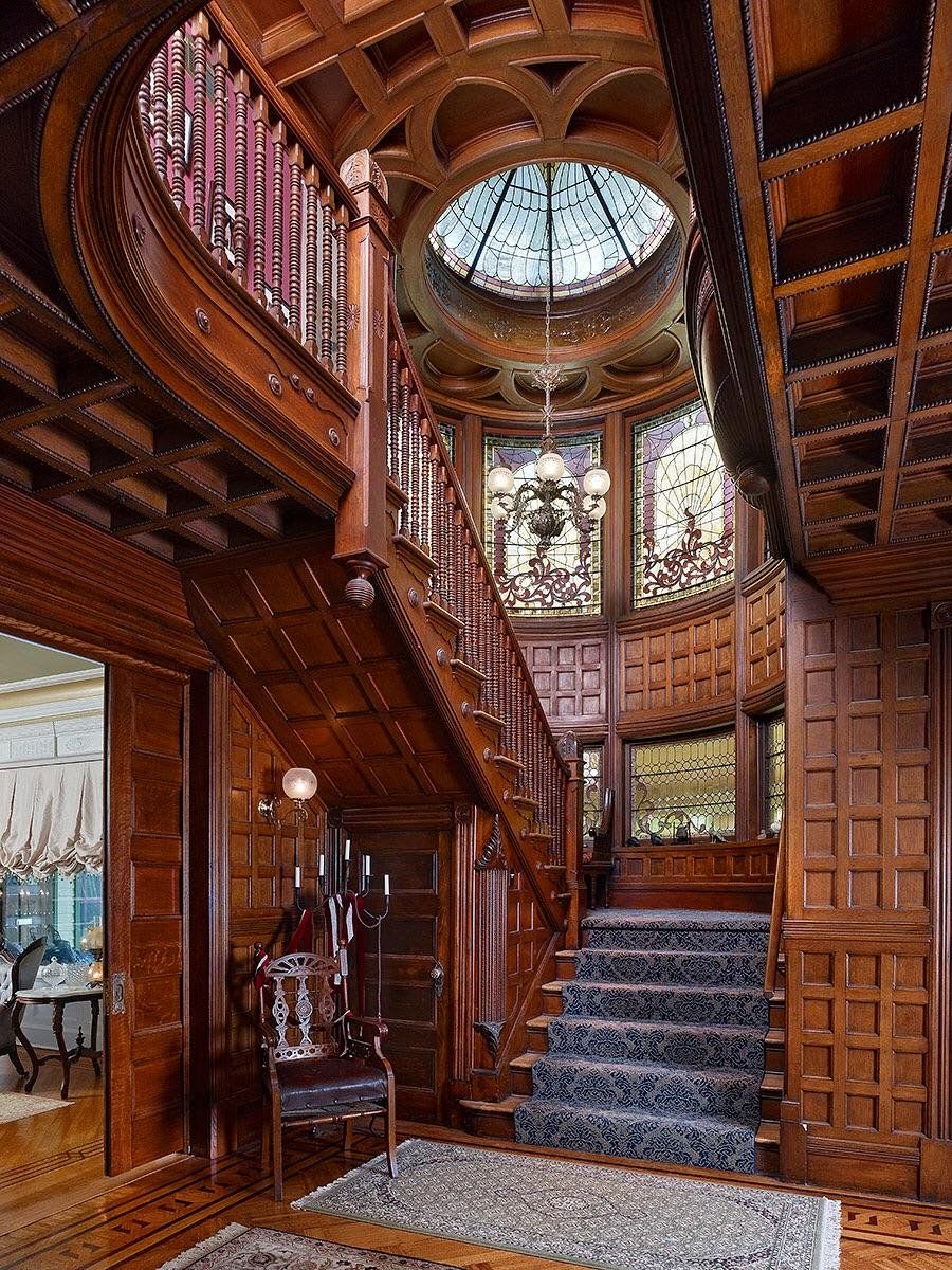 Grand staircase with intricate woodwork and wall panelling in a restored 1893 Queen Anne Victorian mansion, Plainfield, Union County, New Jersey.