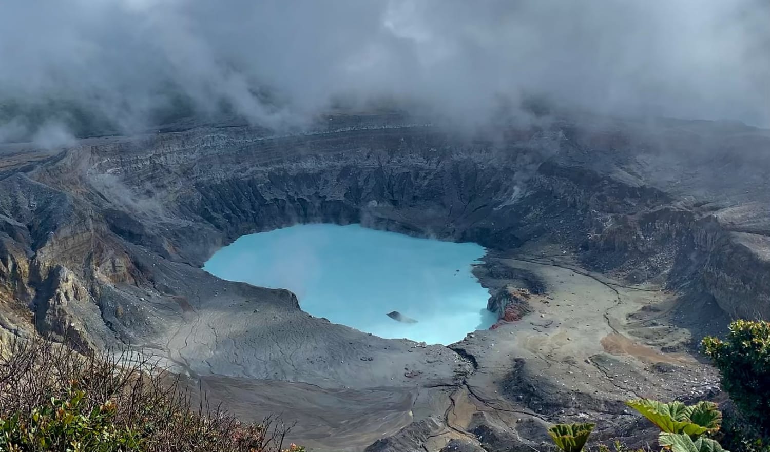 Poas Volcano, Costa Rica (8,848 ft). Sulfuric, bubbling, green rain fed lake at the bottom, surrounded by smoke and steam rising from fumaroles