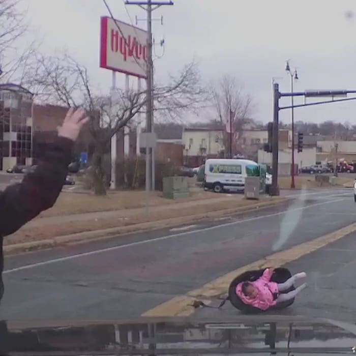 Watch a truck driver rescue a child who tumbled out of a car onto a busy road