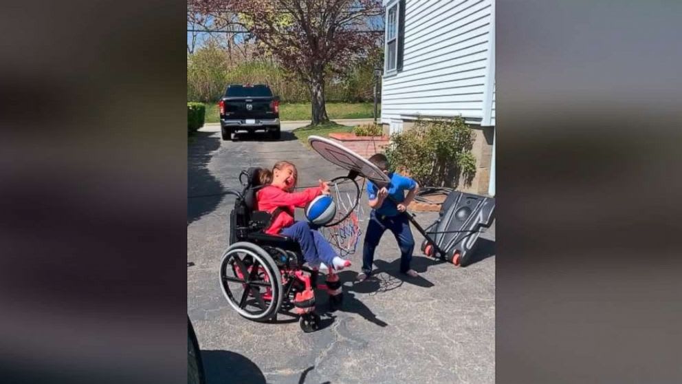 The story behind the viral video of a brother helping his sister dunk a basketball