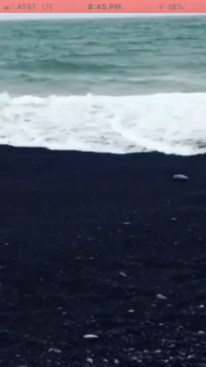 Water disappearing in coarse black sand