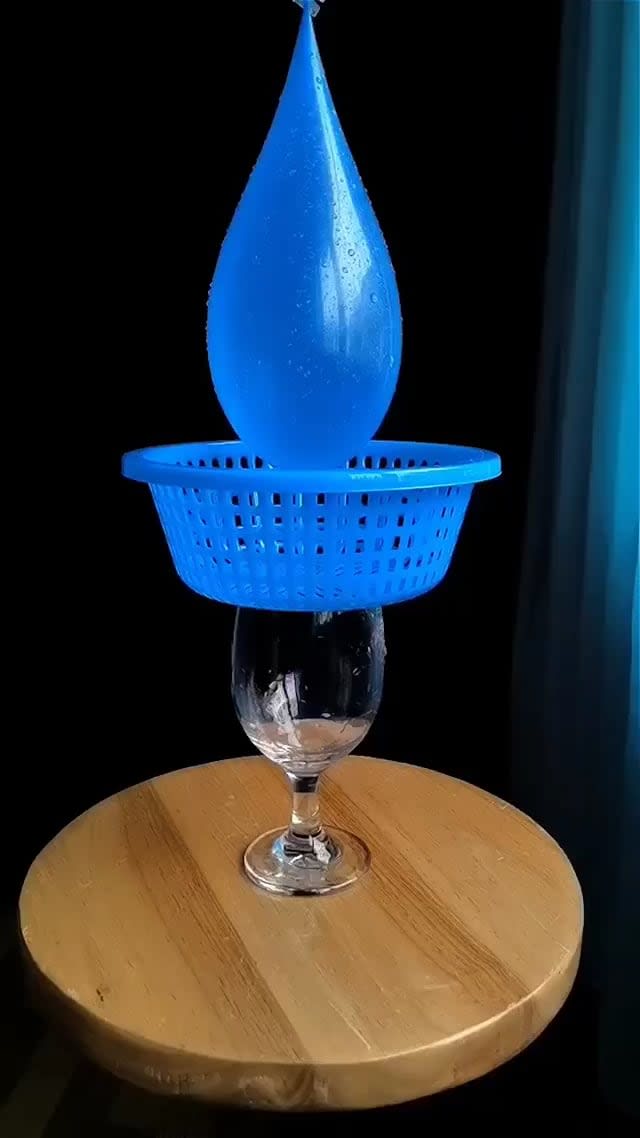 This water balloon bursting in slow motion over a basket and creating a mesmerising effect