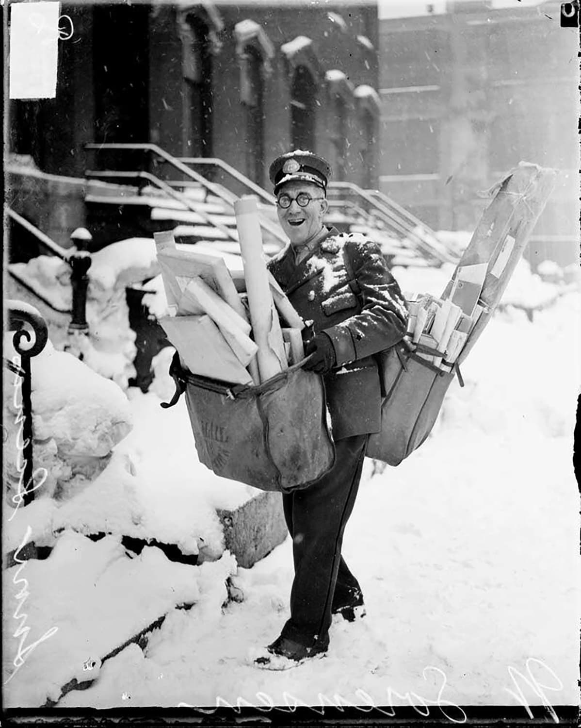 A postman in Chicago posing with heavy Christmas parcels, 1929