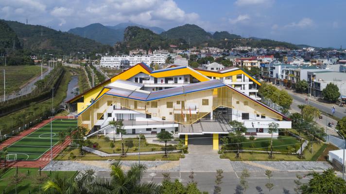 Multi-colored hipped roofs form this kindergarten and primary school in Vietnam