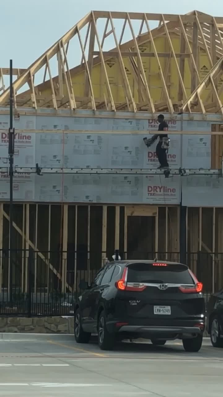 A construction worker consistently throws blocks of wood to the perfect height for almost effortless catching.