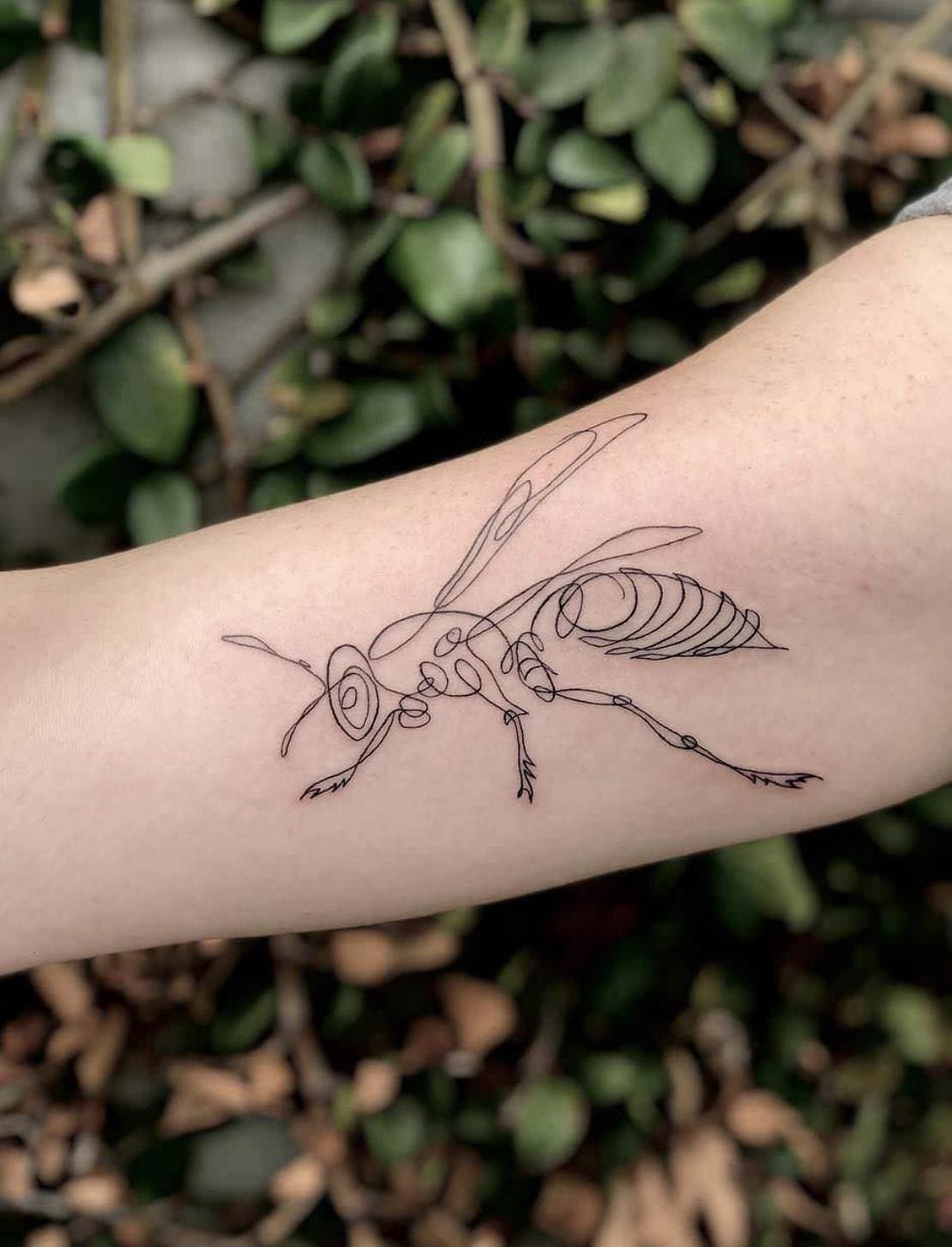 Tattoo of a wasp done with one continuous line