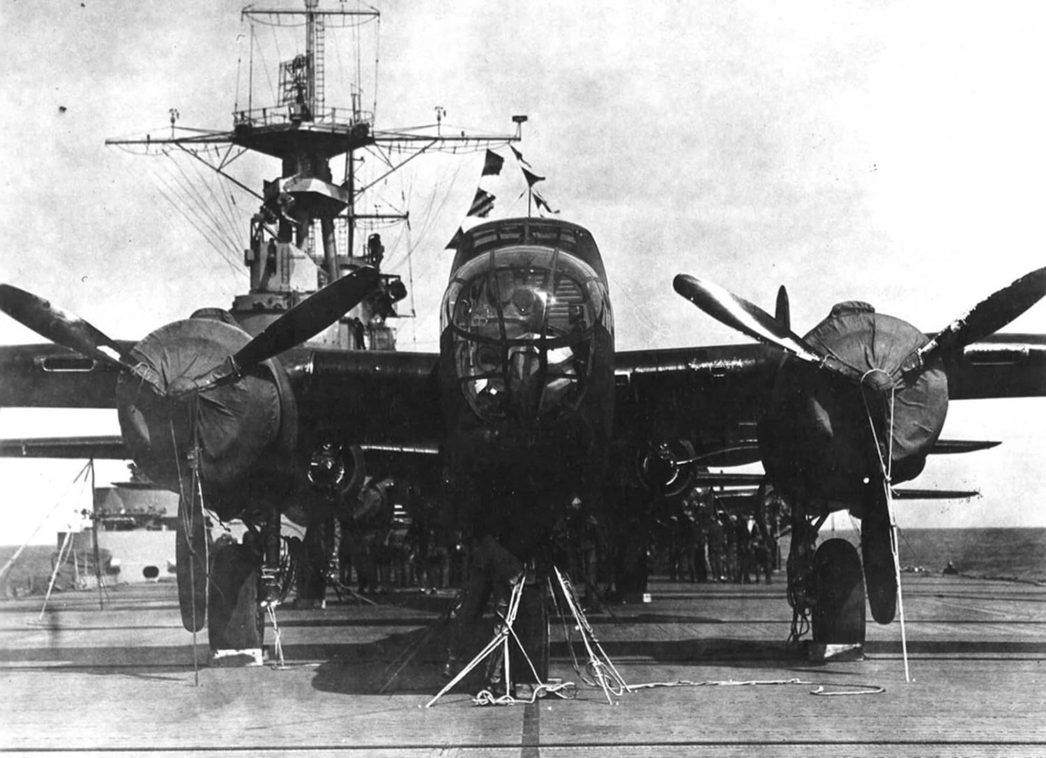 A crew member checks the lashings on his bomber aboard the USS Hornet, while behind him other crews check their planes in preparation for the Doolittle Raid on 18 April 1942