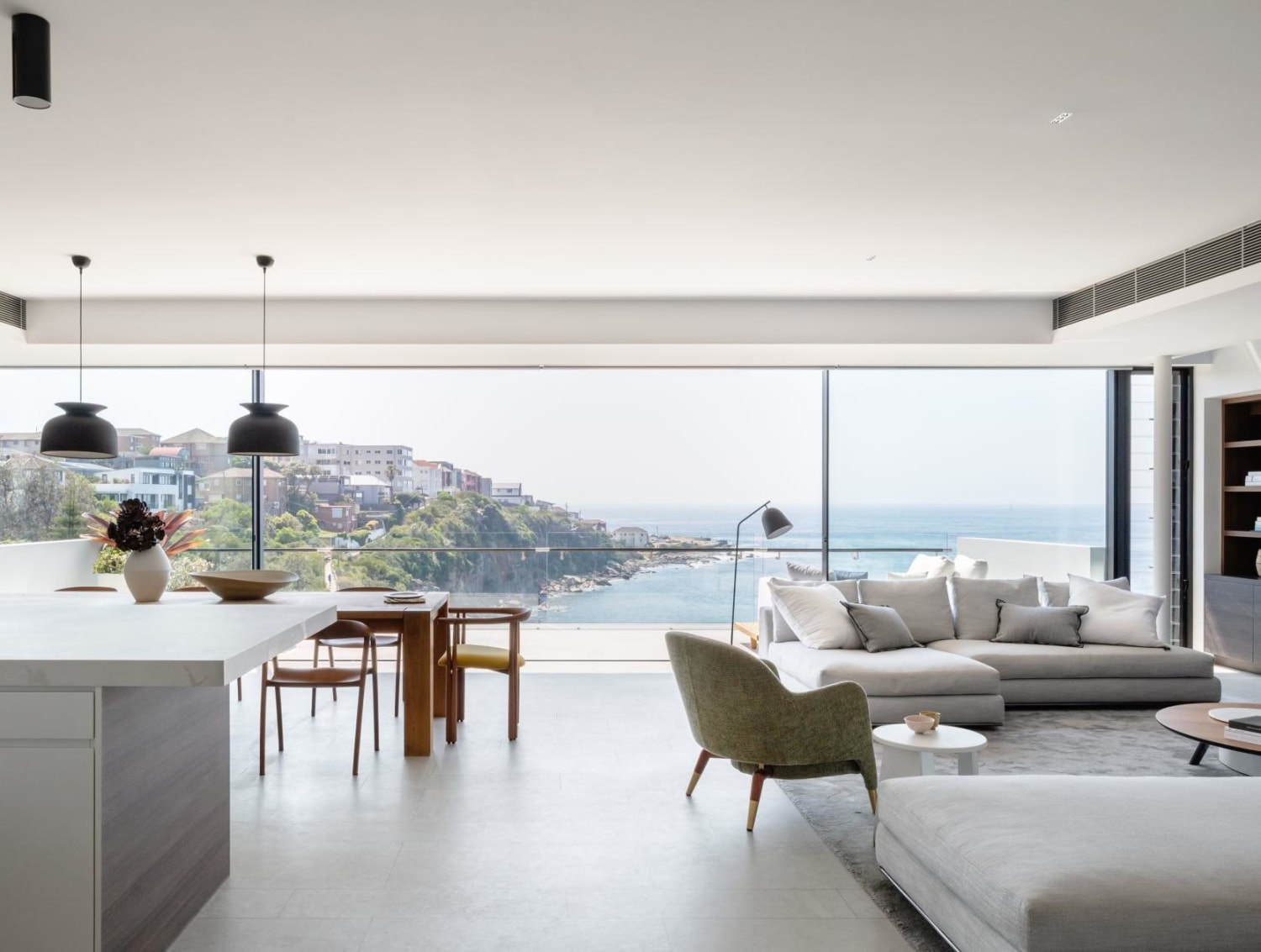 Open space living and dining in an ocean-side home with sweeping views of Gordons Bay, Sydney, Australia by Milieu Creative
