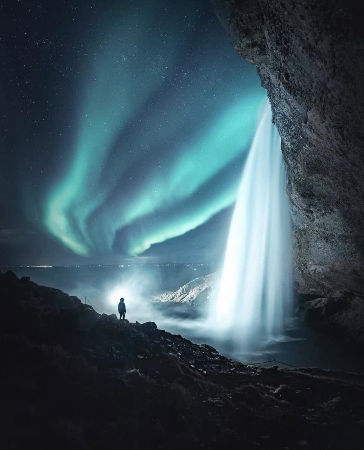 A beautiful wintry shot from Iceland! The waterfall definitely accentuates the Aurora.