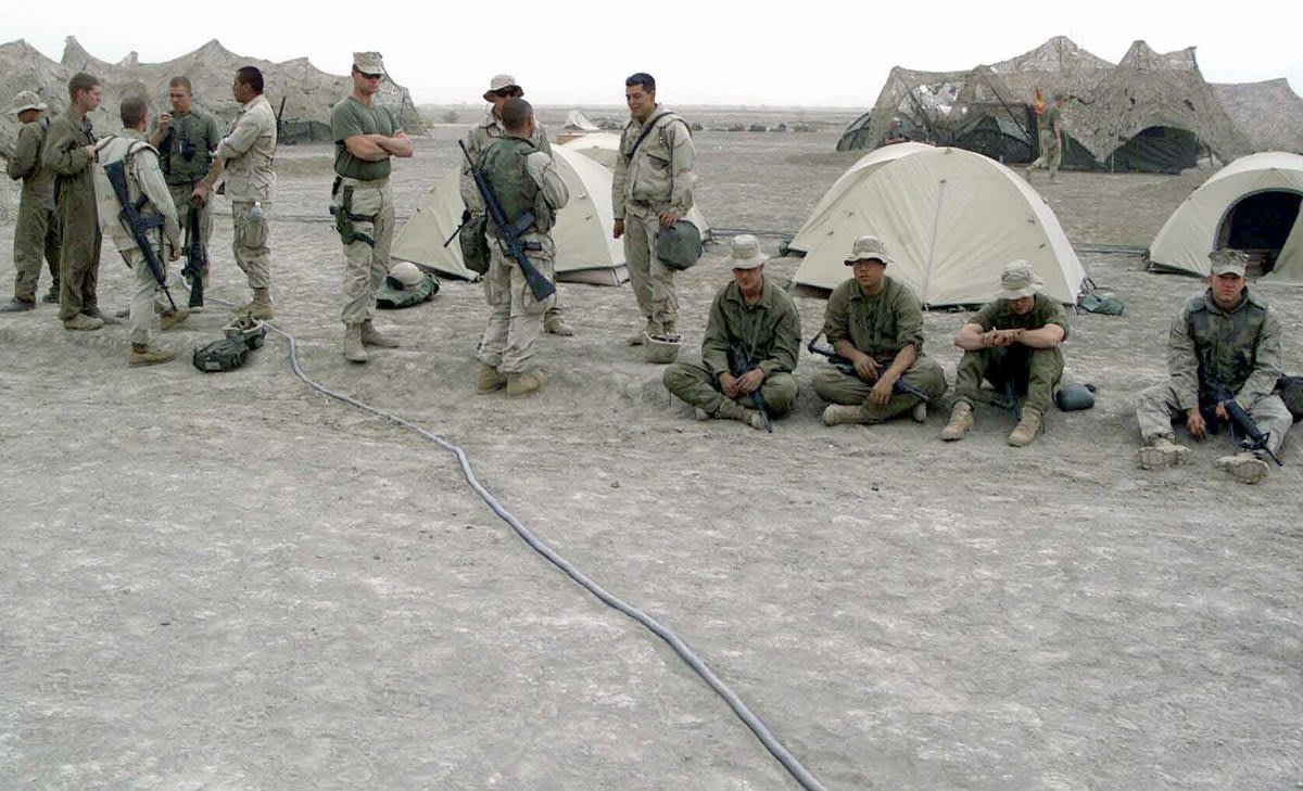 “US Marine Corps (USMC) Marines and US Navy (USN) Sailors…wait in line to call their loved ones back home, while deployed at Camp Fenway, Iraq, during Operation IRAQI FREEDOM, 4/16/2003″ 15 years ago