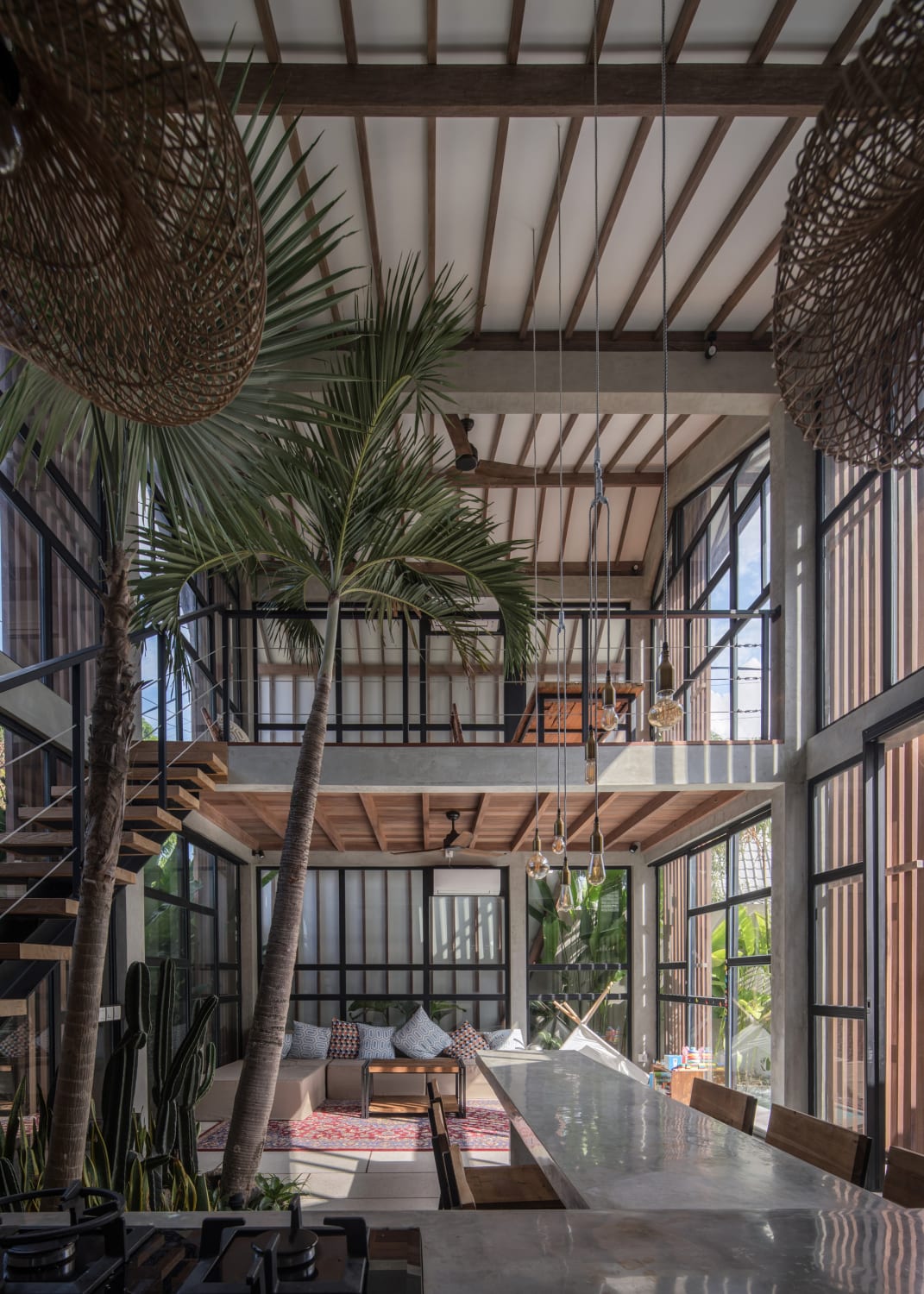Breezy double height living space with indoor plam trees in Canggu, Bali, Indonesia