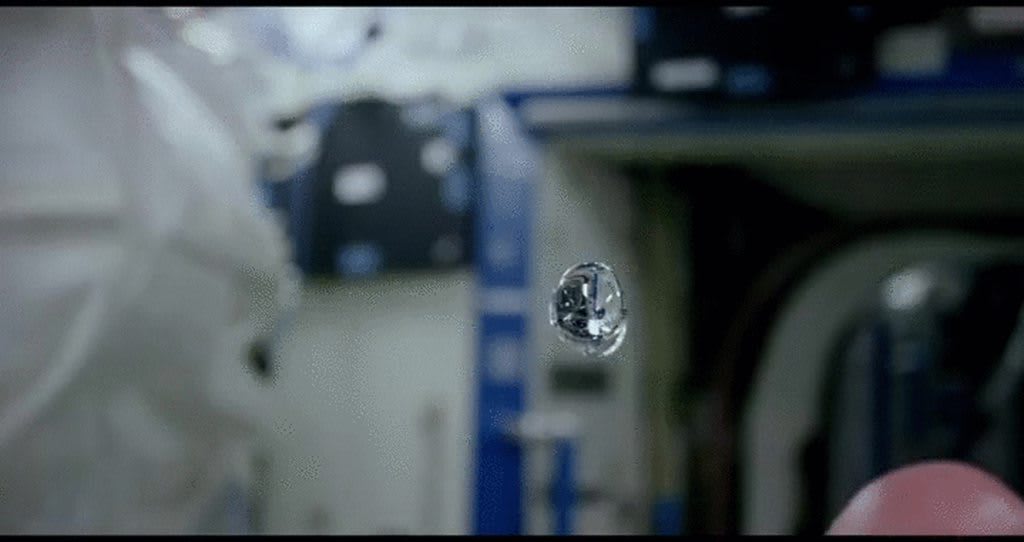 Astronaut Scott Kelly colors floating spheres of liquid in space.