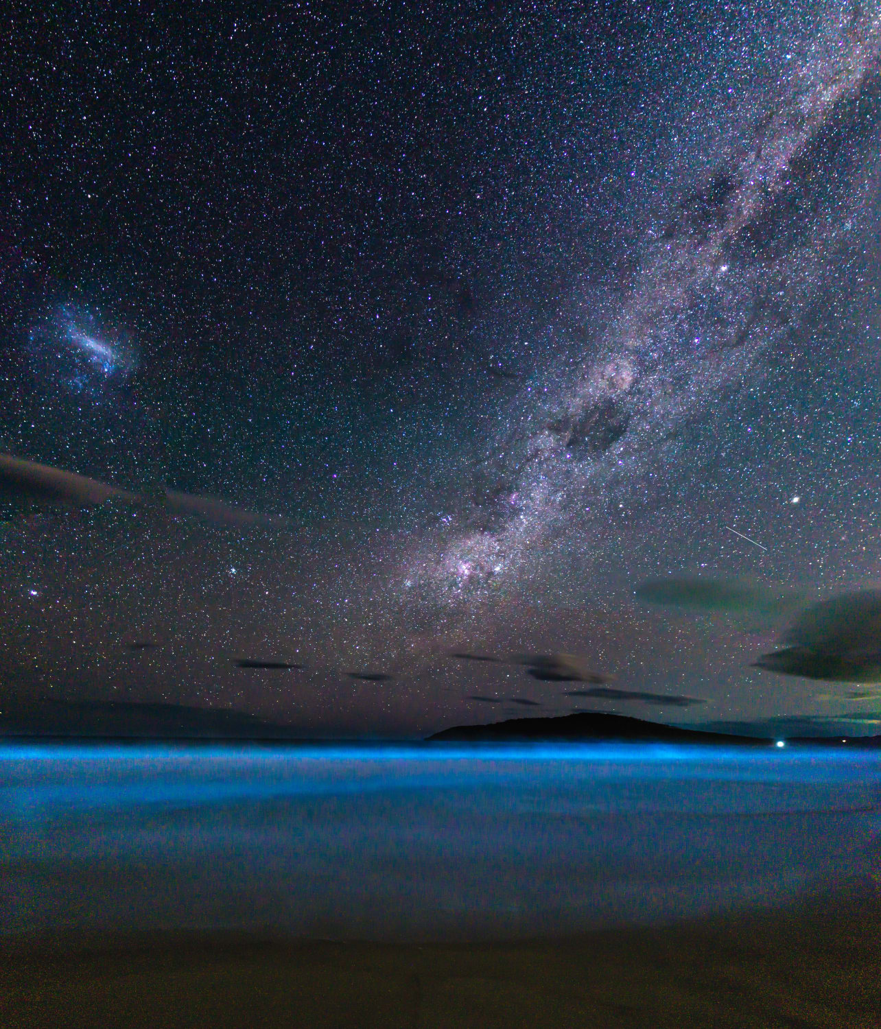 Bioluminescent algae and the milky way rising over South Arm, Tasmania...I believe the ISS is also present just to the right above the clouds!