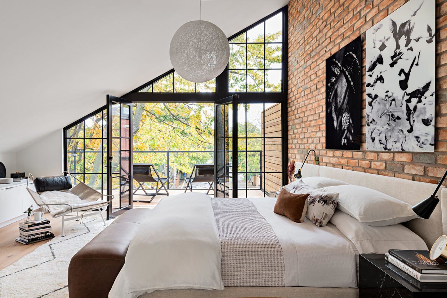 Bedroom with angled roof and exposed brickwork in a narrow semi-detached home, Toronto, Canada by Ancerl Studio (Photo: Gillian Jackson)