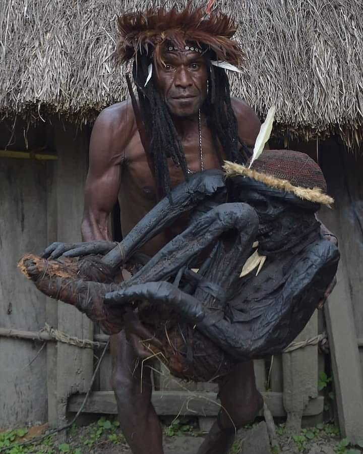 Chief Eli Mabel in Papua holding his mummified ancestor, dead for more than centuries.
