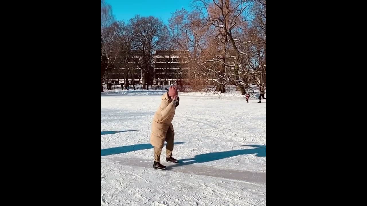 Woman Slips and Falls While Sliding on Frozen Pond - 1181315