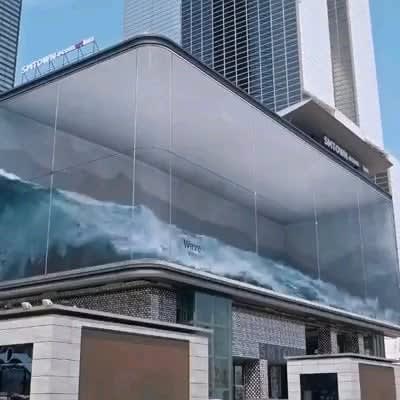 This is a three-dimensional illusion of a wave washing around inside a big glass cube. The futuristic art installation, displayed on a 90 meter wide by 20 meter tall LED board, overlooks a heavily trafficked section of Seoul. It's a creative work by local design company dstrictholdings