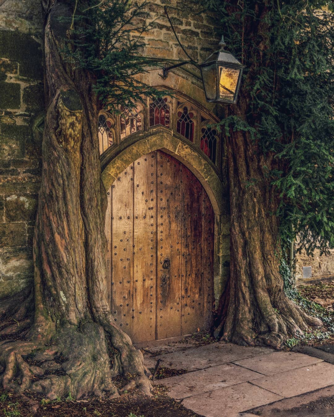 Entrance of the 11th century St Edward's Church flanked by yew trees, Stow-on-the-Wold, Gloucestershire, South West England.