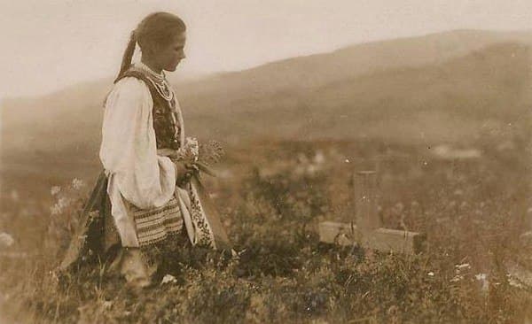 A Slovakian girl kneeling beside the grave of a loved one, Czechoslovakia (1920s)