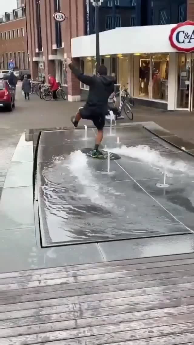 A man surfs on the water with amazing balance.