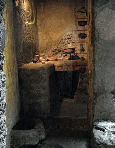 Roman small kitchen in Pompeii. Cooking utensils "still visible" in place. In the fireplace, you can still see a tripod with a cauldron, as well as an assortment of pots.