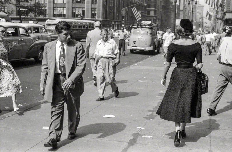People looking at fashion model Doris Erwin as she walks down Fifth Avenue, New York, September 1952. Photo by Ralph Ginzburg for the Look magazine assignment "A Young Man's Fancy -- Model on the Street.”