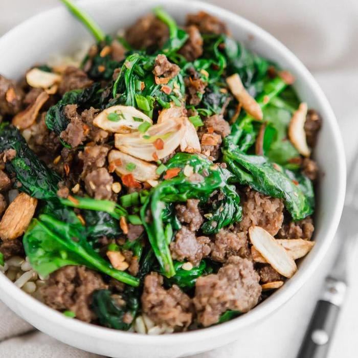 thai beef bowl with garlic and spinach over brown rice