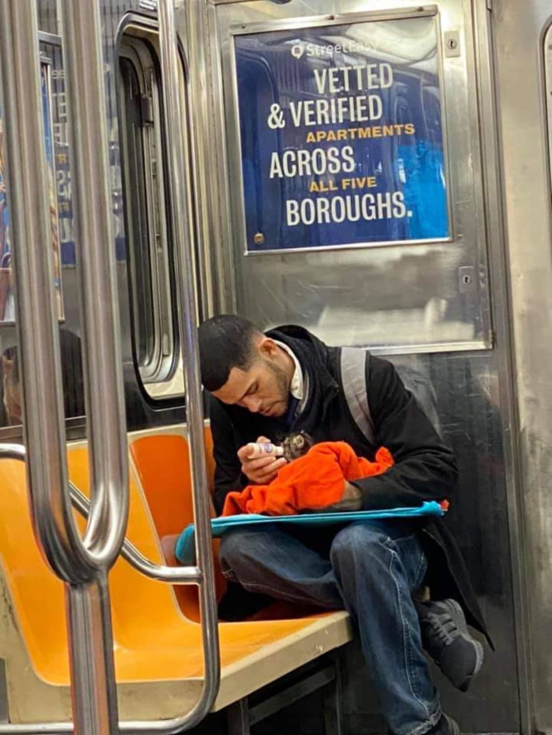 guy feeds a kitten in the subway