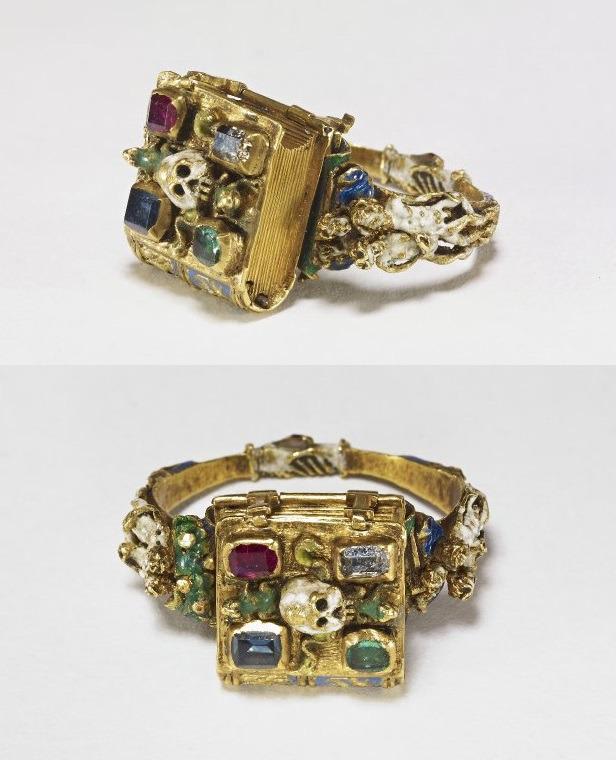 A Memorial Mourning Ring, French or Flemish, from 1526-1575. The book opens to reveal a figure with hourglass and skull, while the back of the loop features clasped hands.