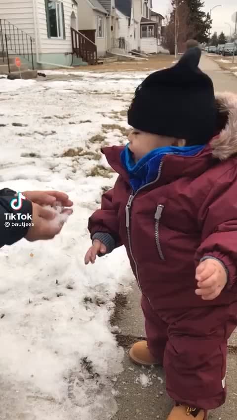 Baby thinks snow is hilarious