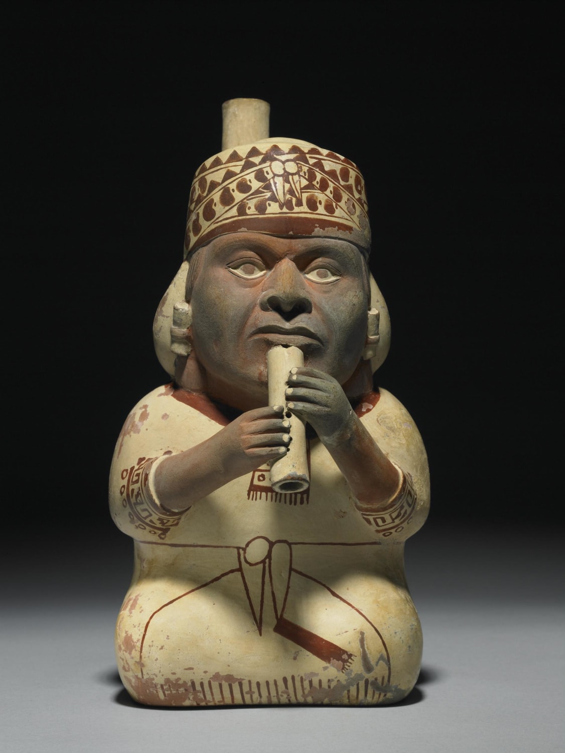 Seated man playing flute. Ceramic, Moche, Peru, 2nd-8th century