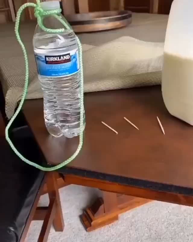 Suspending a water bottle off the edge of a table using toothpicks