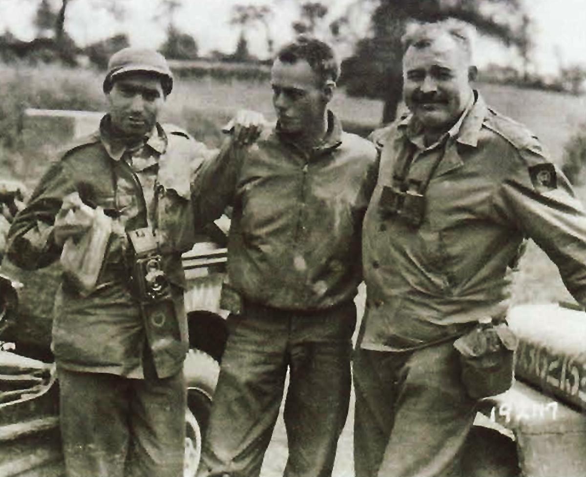 Robert Capa (LIFE photographer) and Ernest Hemingway, (Collier’s magazine) flanking their jeep driver at Pont Brocard, France, July 30th, 1944. Both recorded ‘the greatest invasion in history’ and rode with the 2nd Armored Division during Operation Cobra.