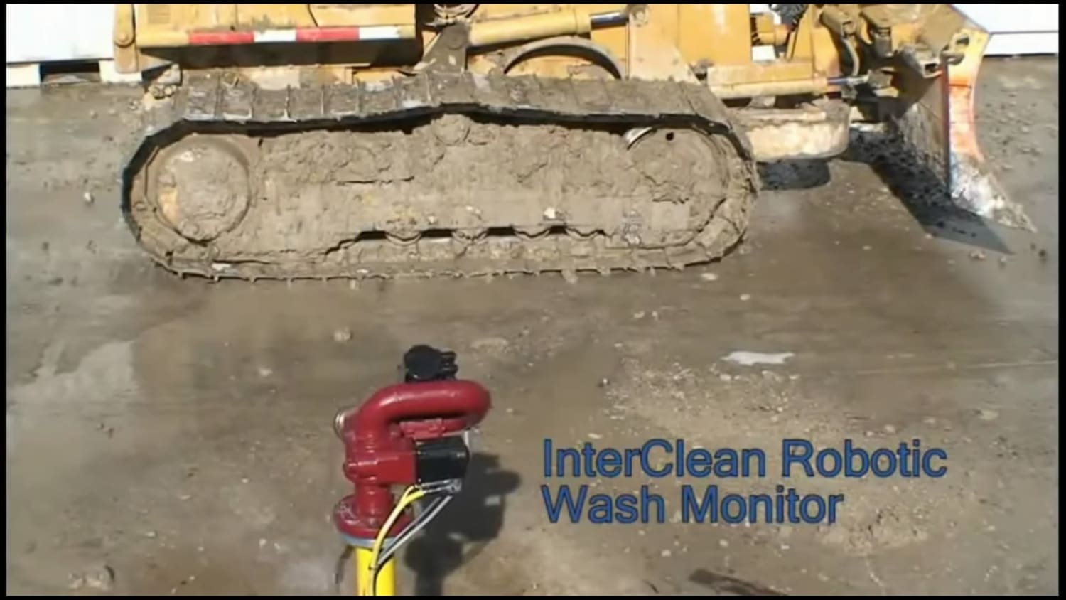 Turret mounted robotic washer cleaning heavy mud from a bulldozer