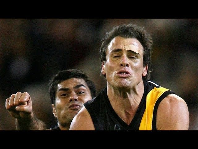 Australian Footballer celebrates kicking the match-winning goal, oblivious to the fact that he has given away a penalty