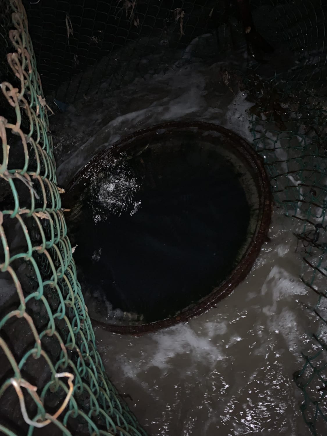 Deep cement hole filled with ocean water right on the shore of Venice Beach, CA. Pretty spooky