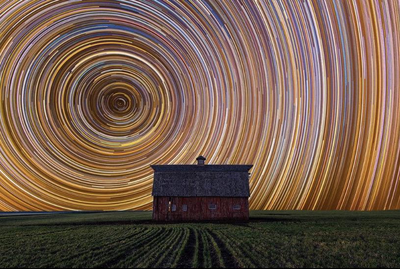 Long exposure of star trails against a farmhouse