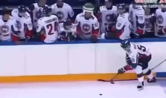 Russian hockey player puts the puck on the stick and throws it in the goal like a javelin