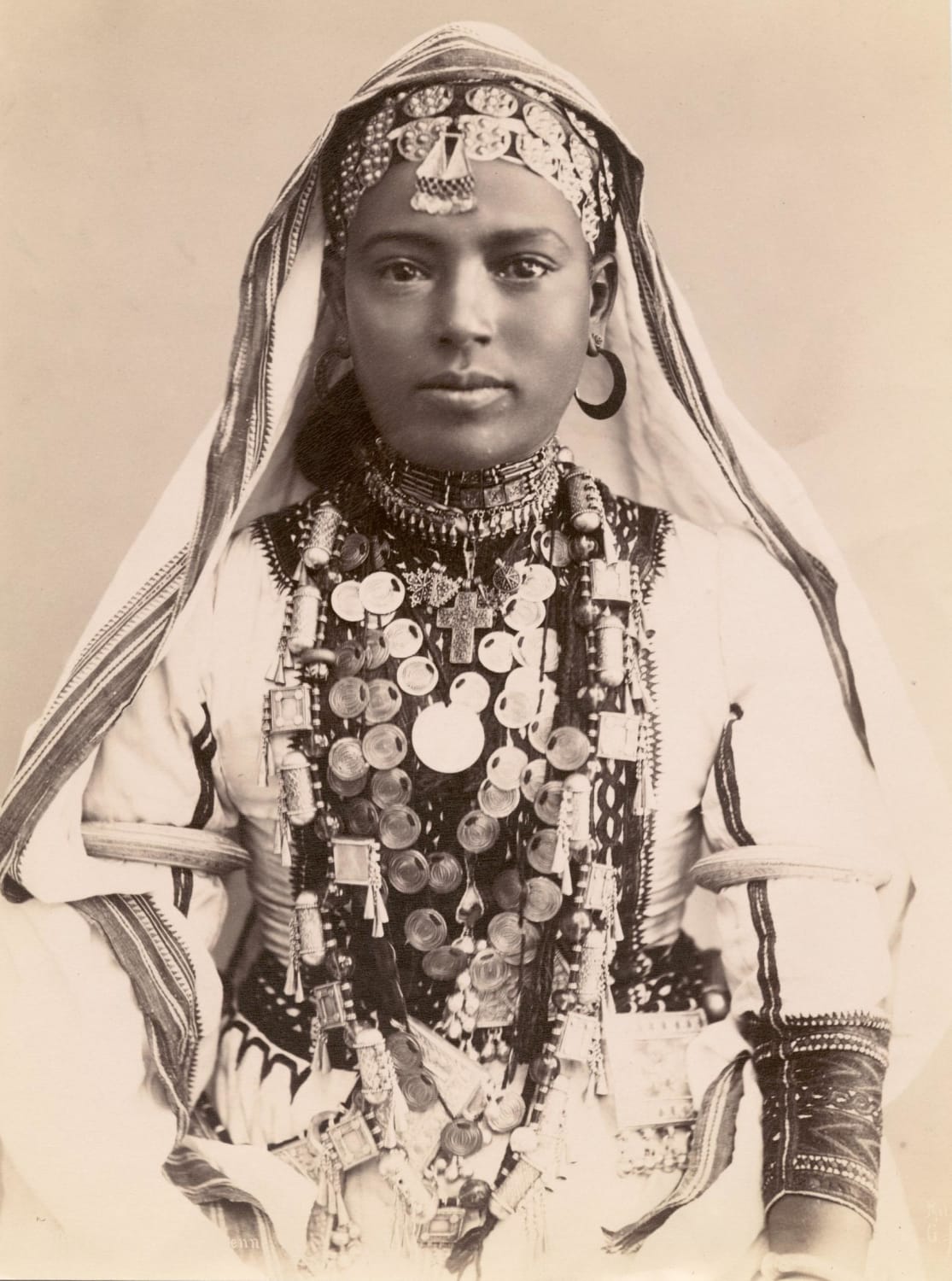 A woman in elaborate robes and jewelry, either Syria or Egypt, circa 1910.