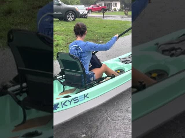 Woman Kayaks on Flooded Florida Street With Her Son - 1208321