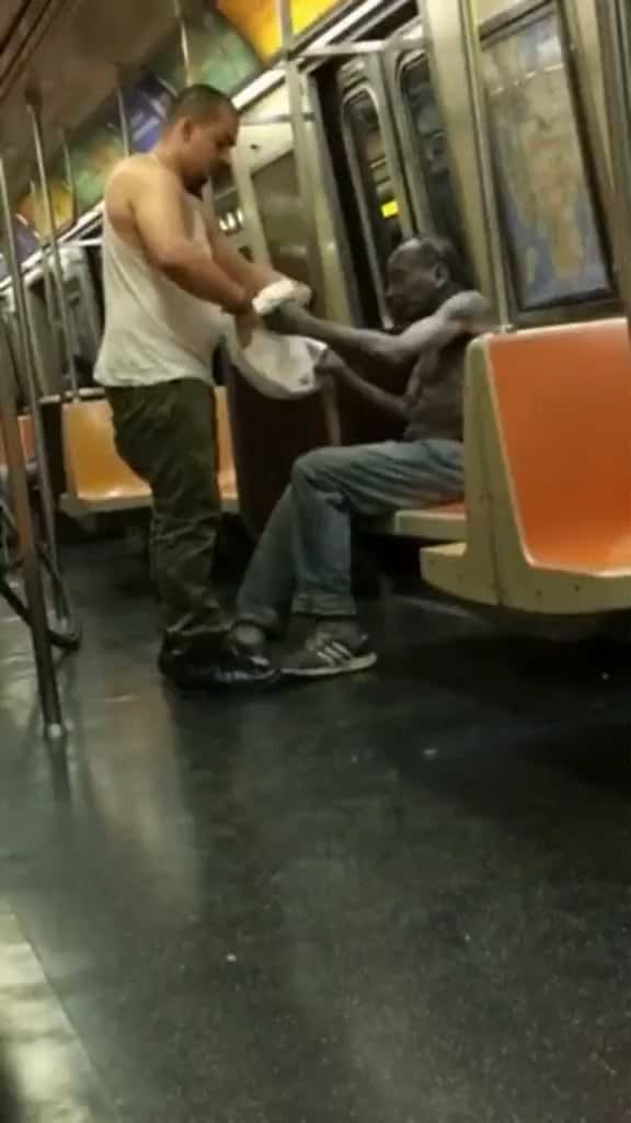 A man gave the shirt off his back to a homeless man on an NewYork Subway .