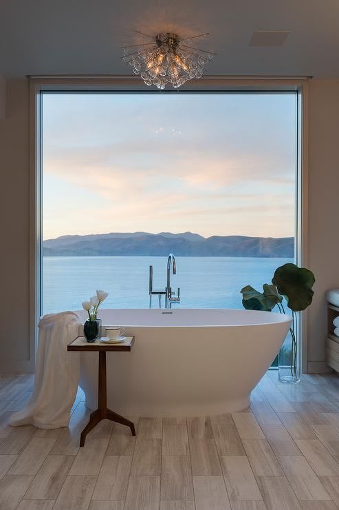 Water front home boasts a restful bathroom featuring a floor to ceiling picture window positioned behind an oval fre… | Dream home design, House design, Dream house