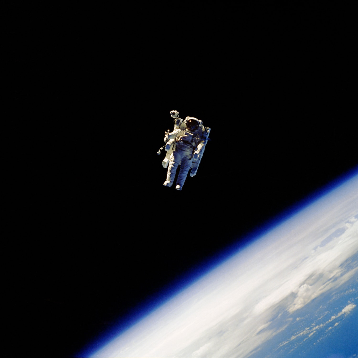 NASA Astronaut Robert L. Stewart "uses his hands to control his movement in space while using the nitrogen propelled Manned Maneuvering Unit (MMU)" as he orbits above Earth in February 1984. "He is floating without tethers attaching him to" NASA's Space Shuttle Challenger (STS-41B).