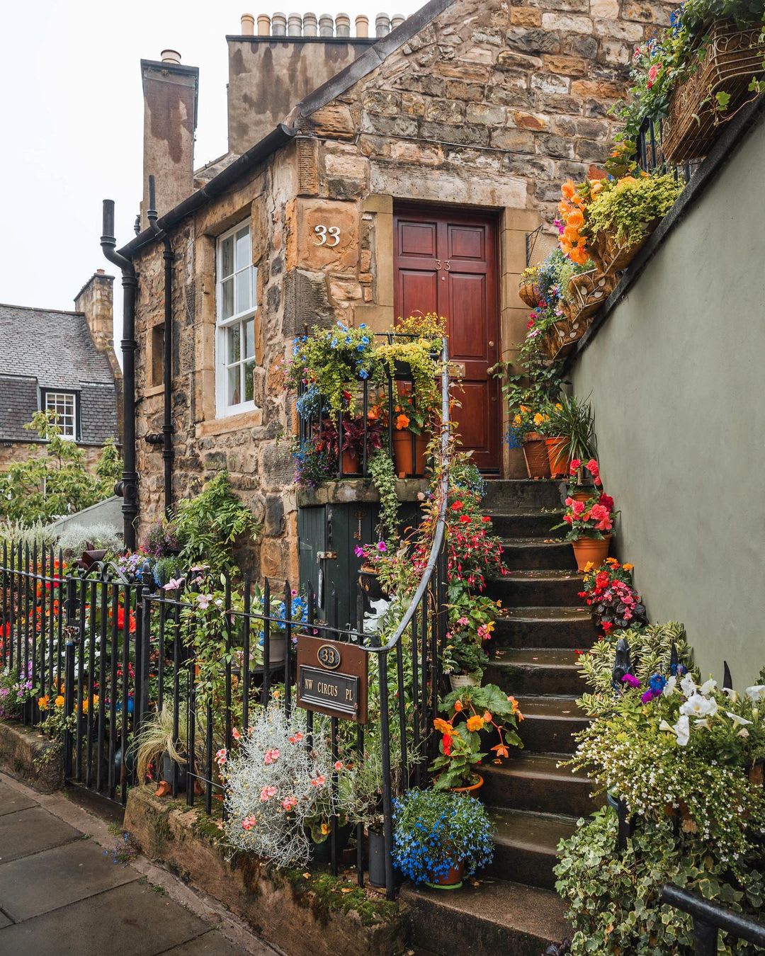 Stone cottage adorned with flowers in Stockbridge, Edinburgh, Scotland.