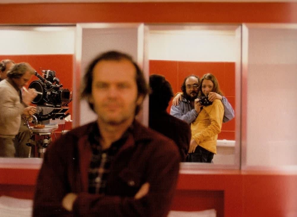Stanley Kubrick taking a mirror selfie with his daughter, Vivian Kubrick while pretending to take a photo of Jack Nicholson, on the set of The Shining (1980)