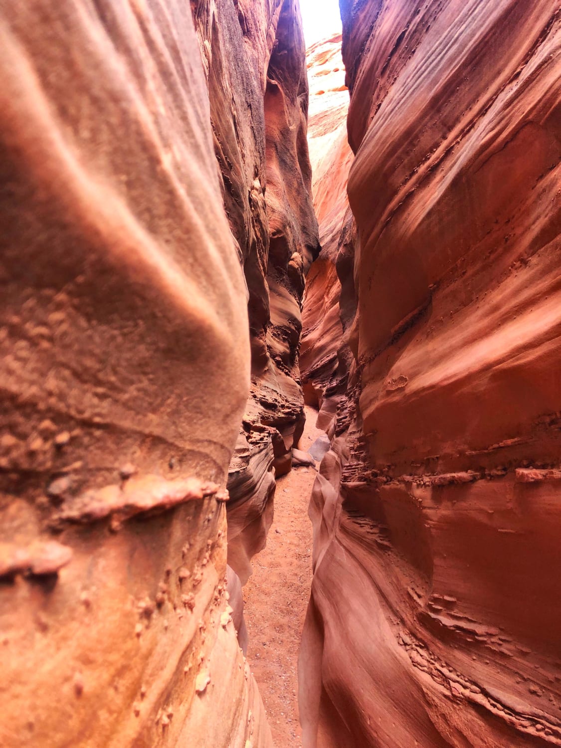 Squeezing through spooky canyon - Grand Staircase-Escalante National Monument, UT, US.