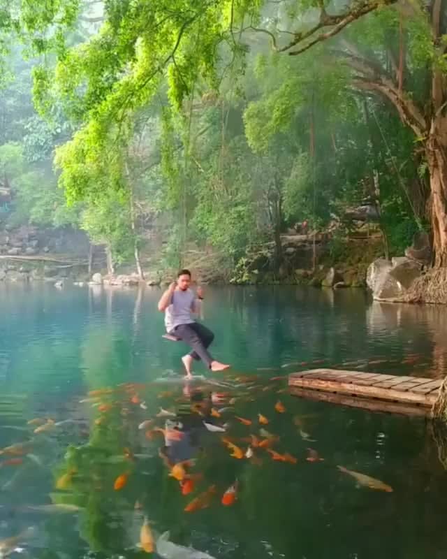 Swing above a natural koi fish lake at Telaga Biru Cicerem